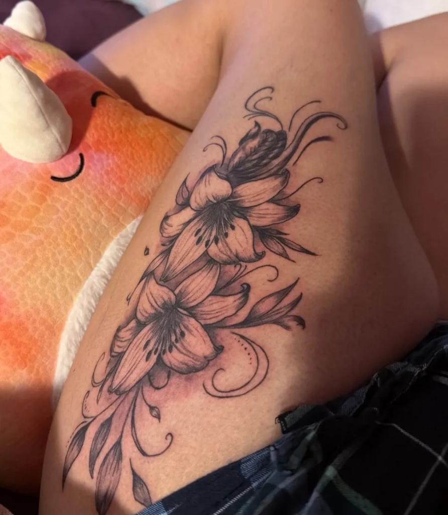 Tatuaje de virgen con flores y rosario en el brazo
